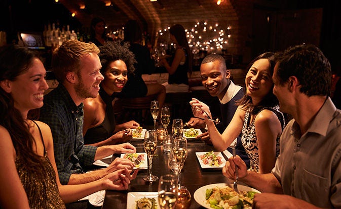 Friends around table enjoying a meal.