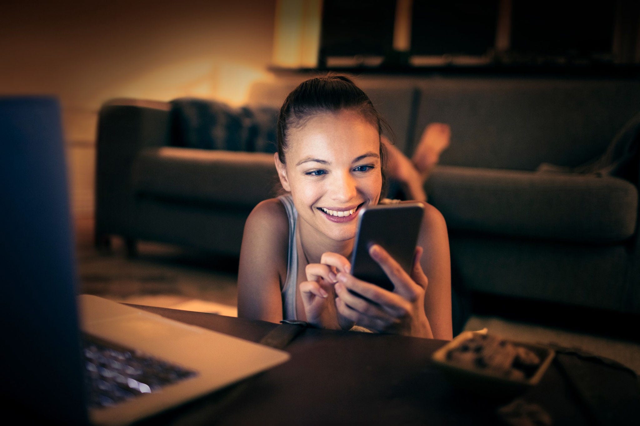 Woman smiling while scrolling her phone