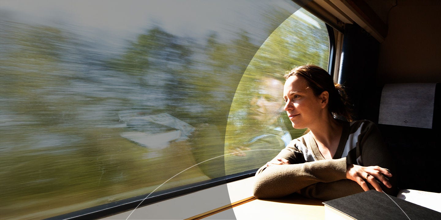 Woman riding train looking out of window.
