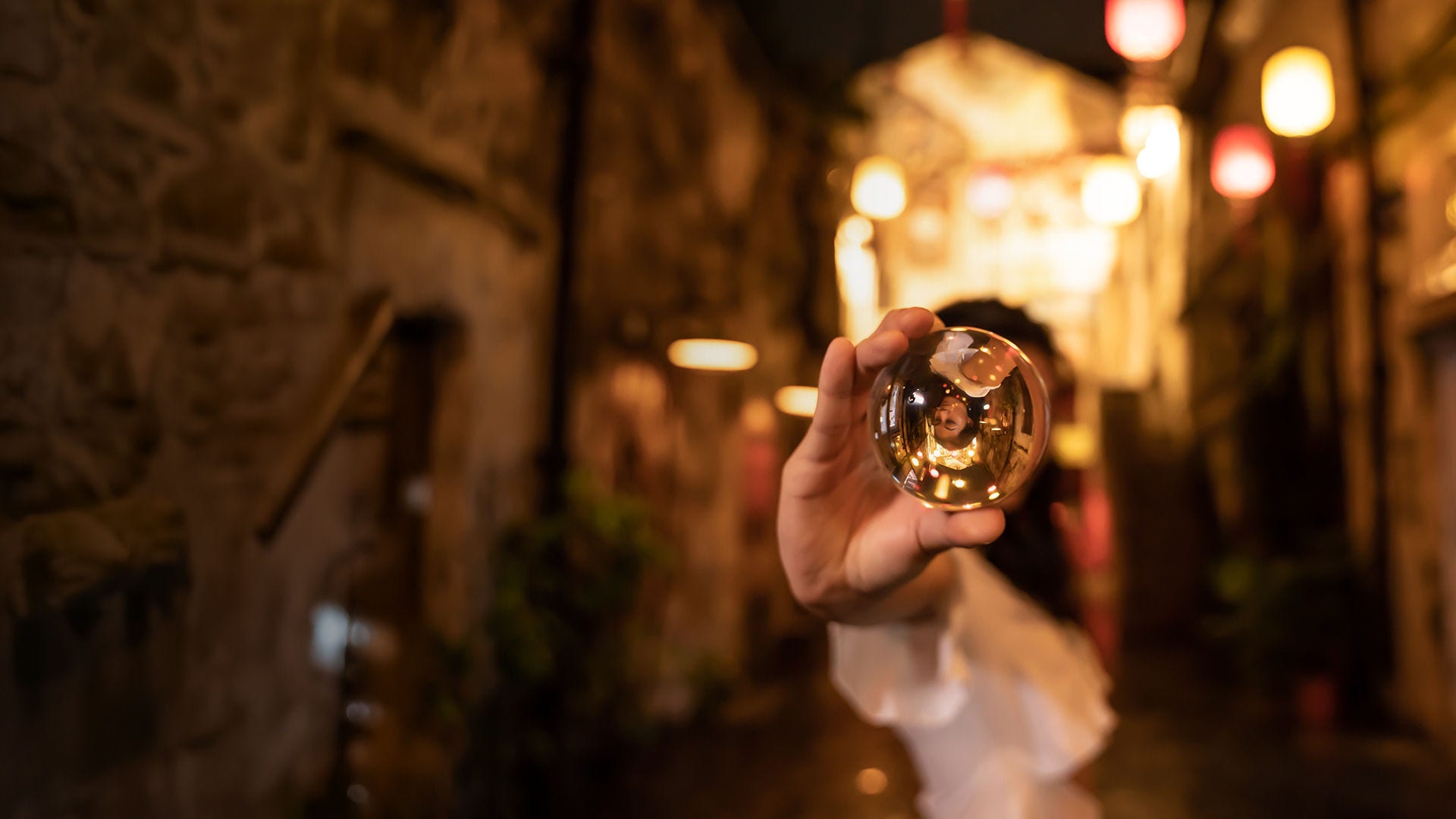 Asian woman holding crystal ball in street desktop banner.
