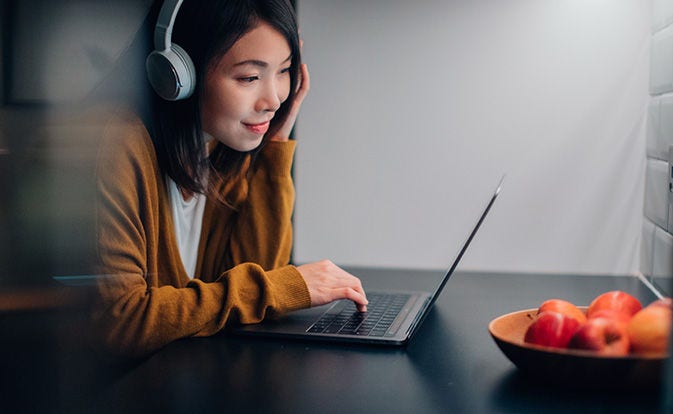Young woman with headphone using her laptop.