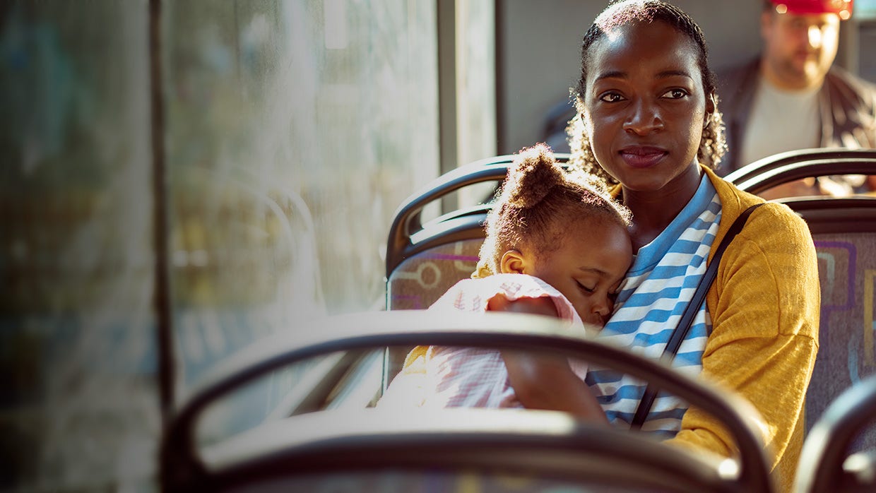 Mother looking away while holding young daughter.