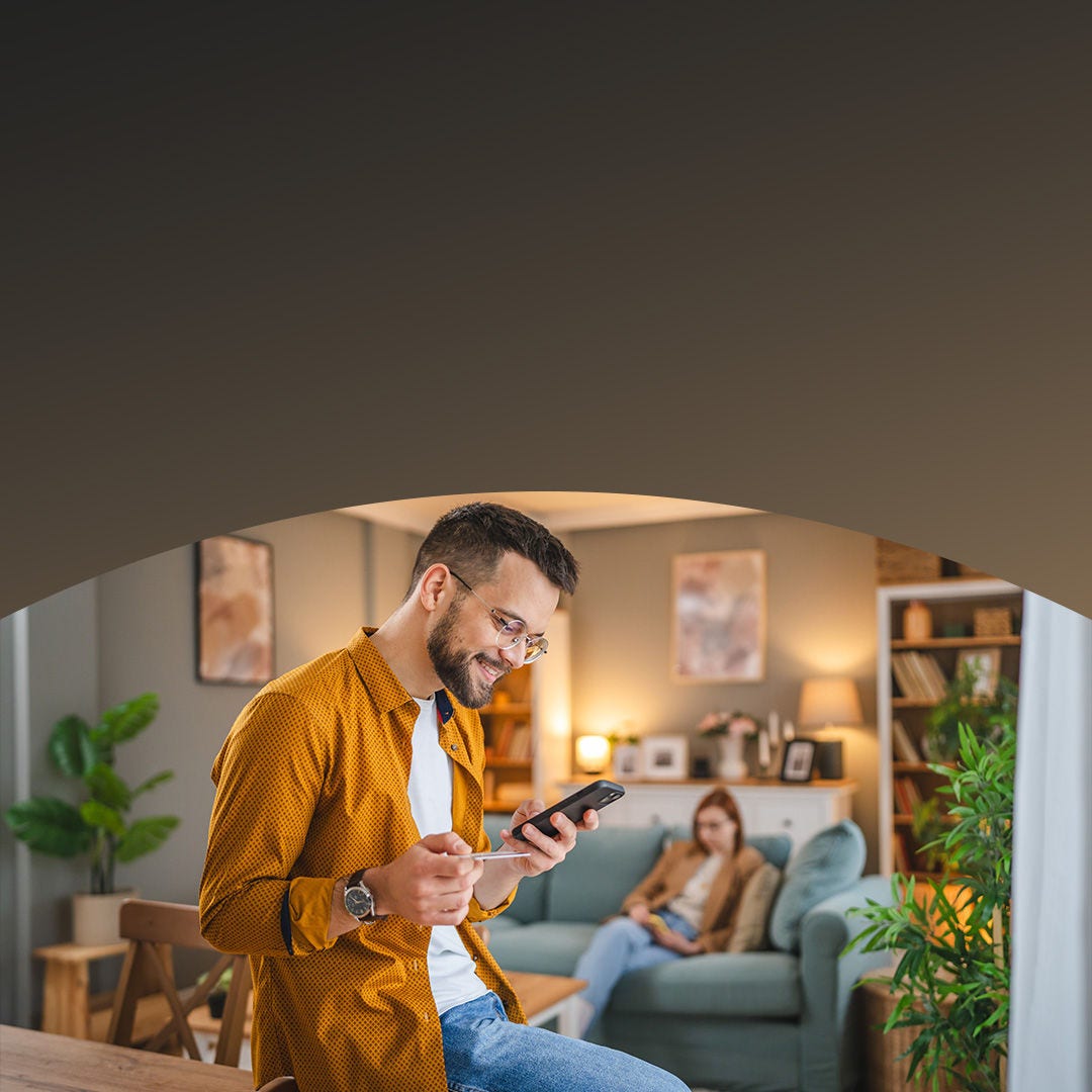 man in glasses shopping with card on phone.