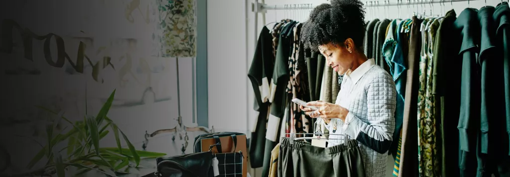 woman smiling while shopping and looking at her phone