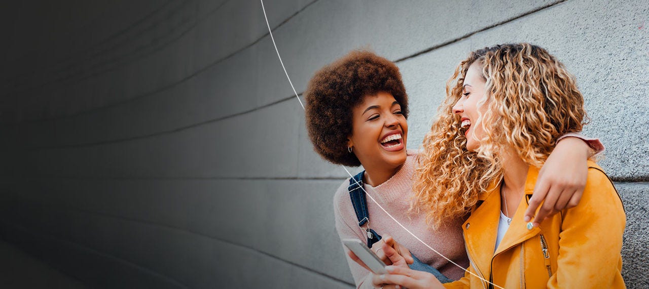 Two smiling people enjoying the benefits of being a Mastercard cardholder.