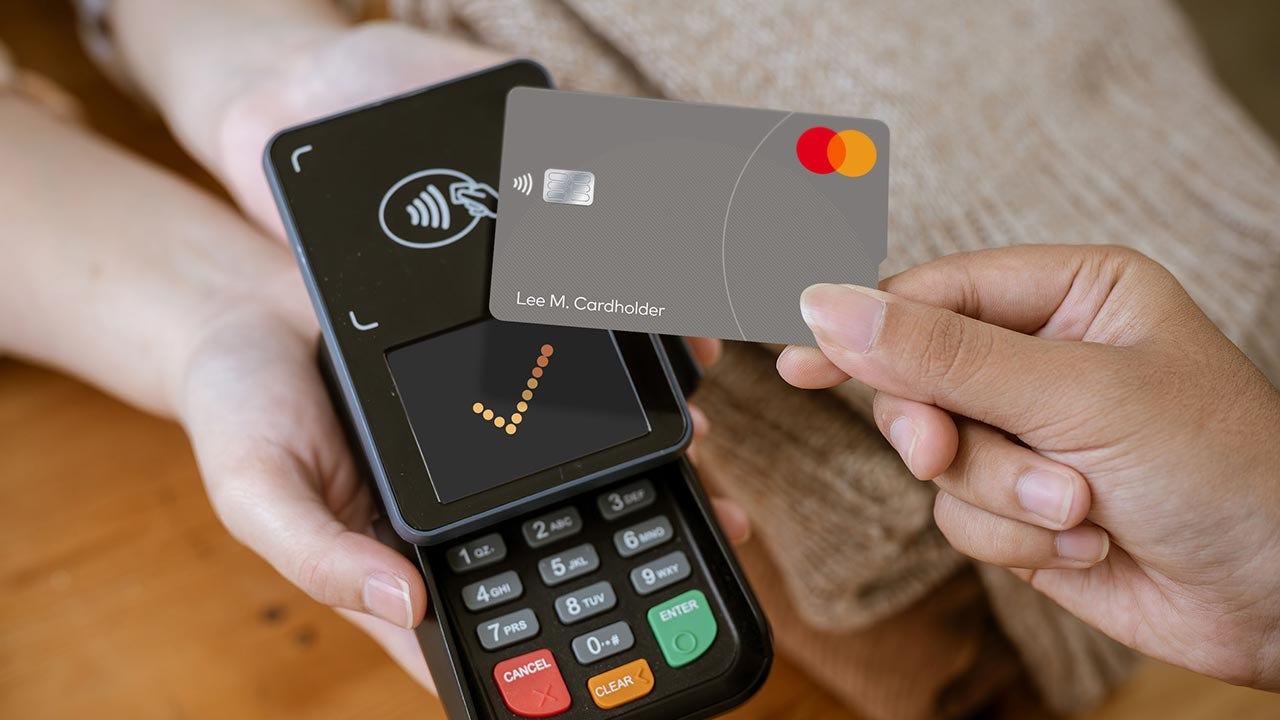 Tapping touch card on payment terminal in store.