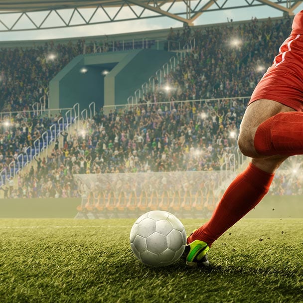 Person kicking a soccer ball in a professional game.