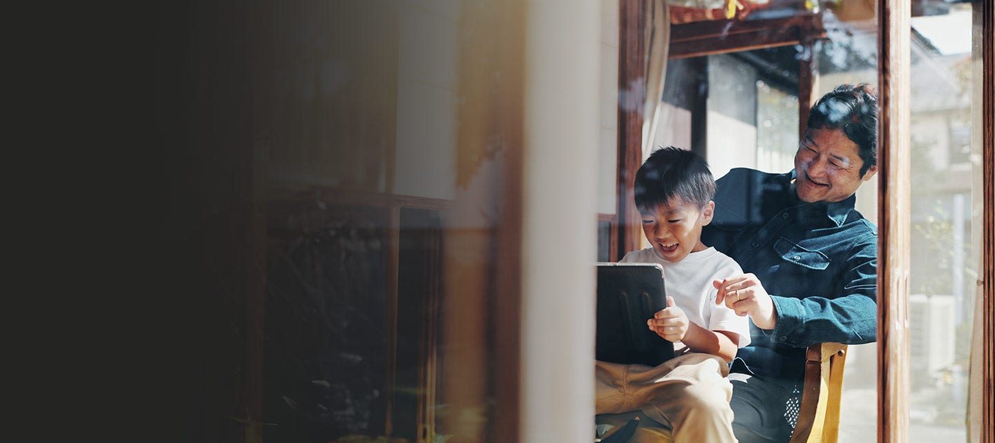 Father and son using a tablet.