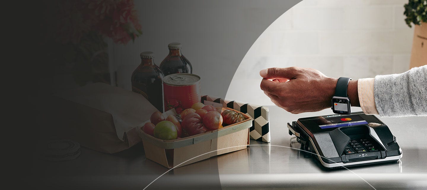 Person making a purchase with their watch at a merchant payment terminal.