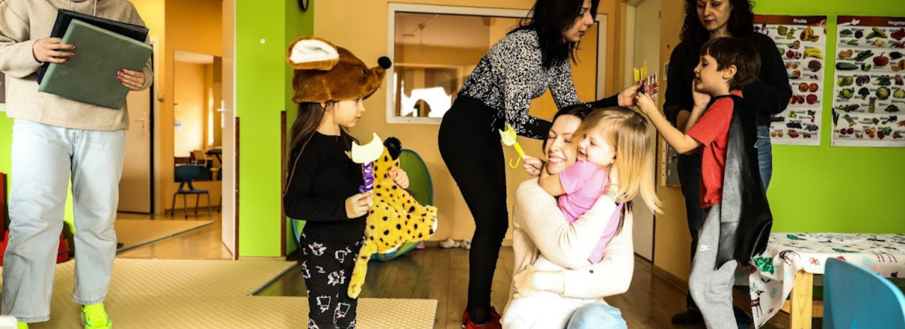 A woman talks to children at a daycare center. 