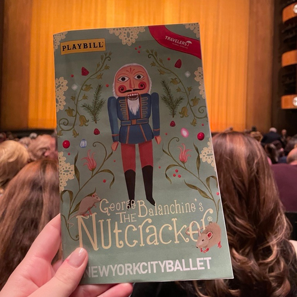 A hand holding up a Playbill of George Balanchine's The Nutcracker; at New York City Ballet in Lincoln Center. 