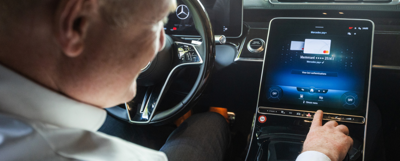 A man hits a button on an in-dash screen.